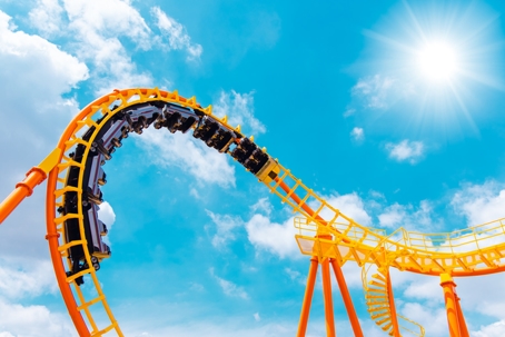 Roller coaster high in the summer sky at theme park