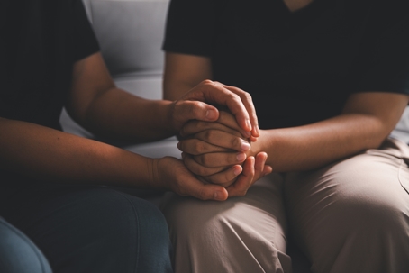 Hope and trust with crisis concept. Closeup, love and holding hands for support, comfort and care with grief, loss and empathy. people and family with compassion, sympathy and healing with bonding. stock photo