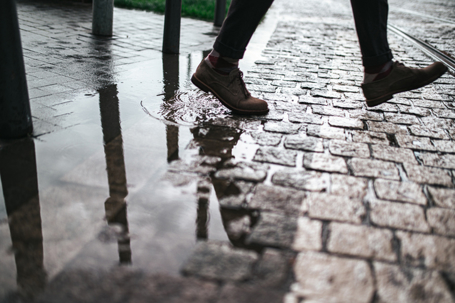 Close up of men's shoes waking during rainy day in the city stock photo